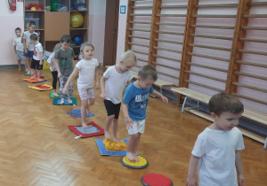 Dzieci przechodzą po matach sensorycznych.