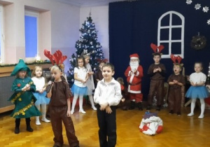 Chłopiec śpiewa kolędę, a reszta grupy ustawiona w półkolu.
