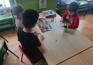 Dzieci przy stolikach grają w gry planszowe.