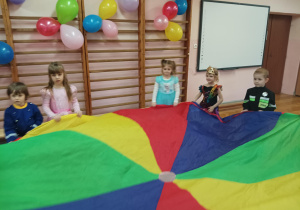 dzieci tańczą i trzymają chustę animacyjną