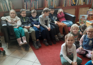Dzieci siedzą w bibliotece.