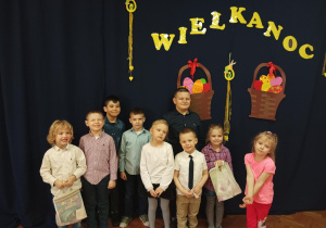 grupa dzieci pozuje do zdjęcia, w tle napis "Wielkanoc 2023"