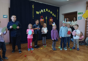 dzieci z grupy 3 prezentują piosenkę, w tle napis "Wielkanoc 2023".