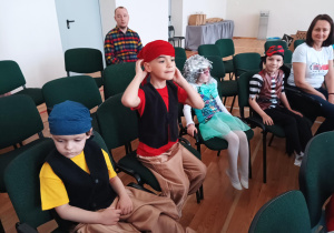 dzieci przebrane za piratów, siedzą na krzesłach na dużej sali