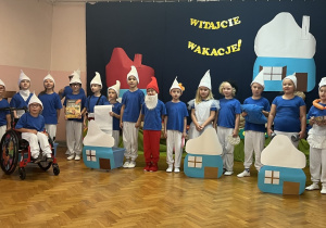 Smerfy ustawione w półkolu recytują wiersz.