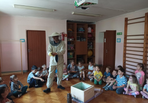 dzieci zebrane na sali gimnastycznej oglądają ul i domek dla pszczół