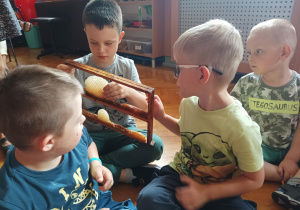 dzieci zebrane na sali gimnastycznej oglądają plastry miodu