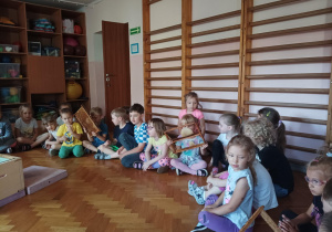 dzieci zebrane na sali gimnastycznej oglądają ul i domek dla pszczół