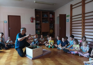 dzieci zebrane na sali gimnastycznej oglądają ul i domek dla pszczół