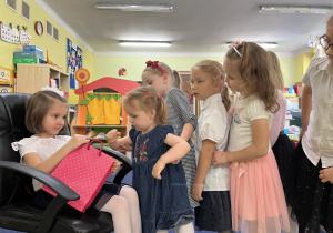 Dzieci składają życzenia i biorą cukierki.