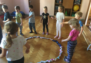 Dzieci w kole bawią się sigumą.