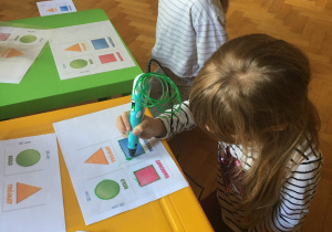 Dzieci rysują figury geometryczne z wykorzystaniem długopisu 3D.