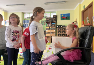 Dzieci ustawione w kole śpiewają "100 lat".