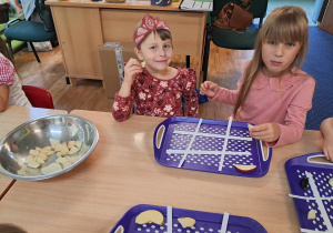 Dzieci siedzą przy stoliku i wykonują owocowe sudoku.