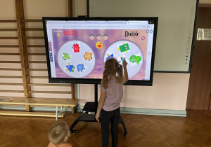 Dziecko wykonuje zadanie na tablicy multimedialnej.