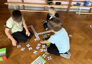 Dzieci wykonują drogę z puzzli dla ozobota.