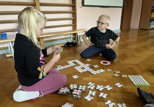 Dzieci wykonują drogę z puzzli dla ozobota.