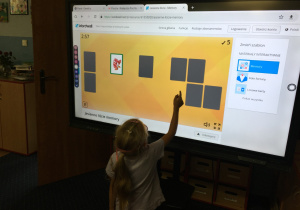 Dzieci wykonują zadanie na tablicy multimedialnej.