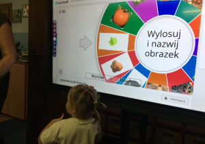 Dzieci wykonują zadanie na tablicy multimedialnej.