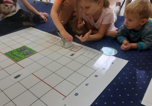 Dzieci wykonują zadanie na macie do kodowania.