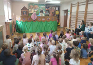 dzieci oglądają przedstawienie kukiełkowe na sali gimnastycznej