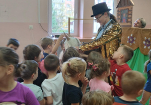 dzieci oglądają przedstawienie kukiełkowe na sali gimnastycznej
