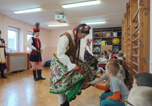 dzieci na sali gimnastycznej oglądają strój krakowski
