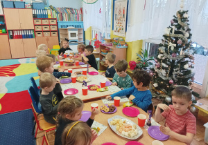 dzieci przy stolikach świętują urodziny koleżanki