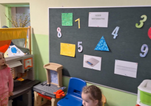 Dzieci stoją i obserwujątablicę.