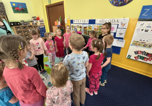 Dzieci stoją w kole i śpiewają "100 lat".