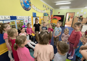 Dzieci stoją w kole i śpiewają "100 lat".