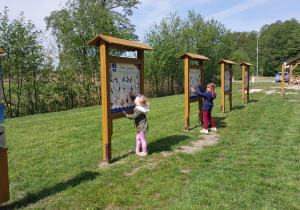 dzieci stoją przy tablicy informacyjnej