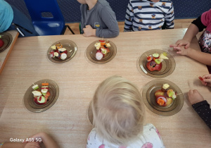 dzieci nadziewają patyczki drewniane cząstkami owoców i warzyw