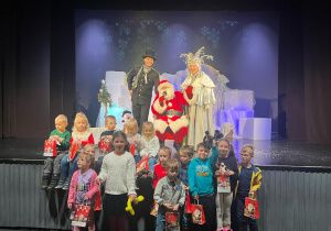 grupa dzieci w teatrze pozuje do zdjęcia z Mikołajem