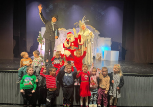 grupa dzieci w teatrze pozuje do zdjęcia z Mikołajem
