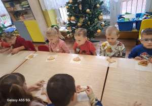 dzieci siedzą przy stolikach, zjadają upieczone gofry