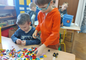 dzieci budują z klocków lego