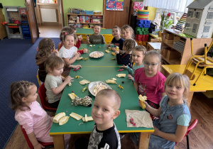 Dzieci siedzą przy stole.