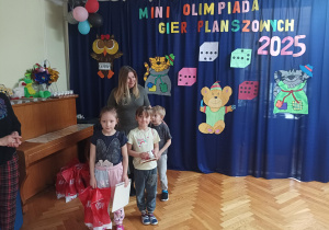 dwie dziewczynki otrzymują nagrody podczas mini olimpiady gier planszowych granna