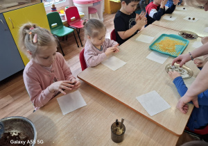 dzieci przy stolikach samodzielnie wykonują słodycze z płatków owsianych, bananów, kakao