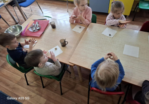 dzieci przy stolikach samodzielnie wykonują słodycze z płatków owsianych, bananów, kakao