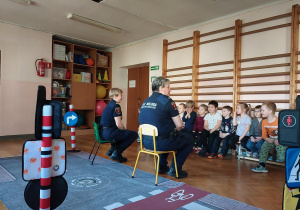 dzieci uczestniczą w zajęciach o bezpieczeństwie na sali gimnastycznej,