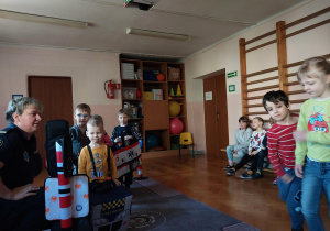 dzieci uczestniczą w zajęciach o bezpieczeństwie na sali gimnastycznej, poruszają się po drodze i po pasach zgodnie z przepisami ruchu drogowego