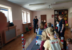 dzieci uczestniczą w zajęciach o bezpieczeństwie na sali gimnastycznej, poruszają się po drodze i po pasach zgodnie z przepisami ruchu drogowego