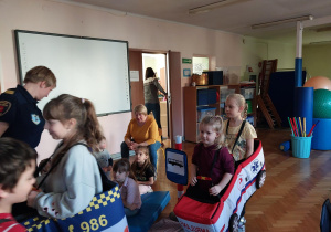 dzieci uczestniczą w zajęciach o bezpieczeństwie na sali gimnastycznej, poruszają się po drodze i po pasach zgodnie z przepisami ruchu drogowego