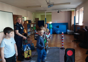 dzieci uczestniczą w zajęciach o bezpieczeństwie na sali gimnastycznej, poruszają się po drodze i po pasach zgodnie z przepisami ruchu drogowego