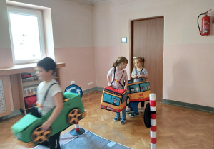dzieci uczestniczą w zajęciach o bezpieczeństwie na sali gimnastycznej, poruszają się po drodze i po pasach zgodnie z przepisami ruchu drogowego