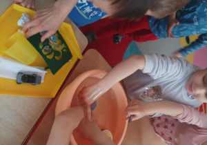 dzieci wykonują eksperymenty wykorzystując wodę, barwniki, cytrynę, sól, cukier, różne przedmioty