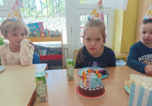 dziewczynka dmucha świeczkę na torcie