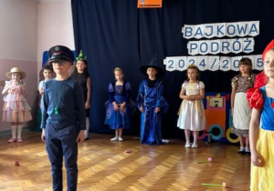 Dzieci ustawione w półkolu, na środku stoi chłopiec przebrany za zawiadowcę stacji.